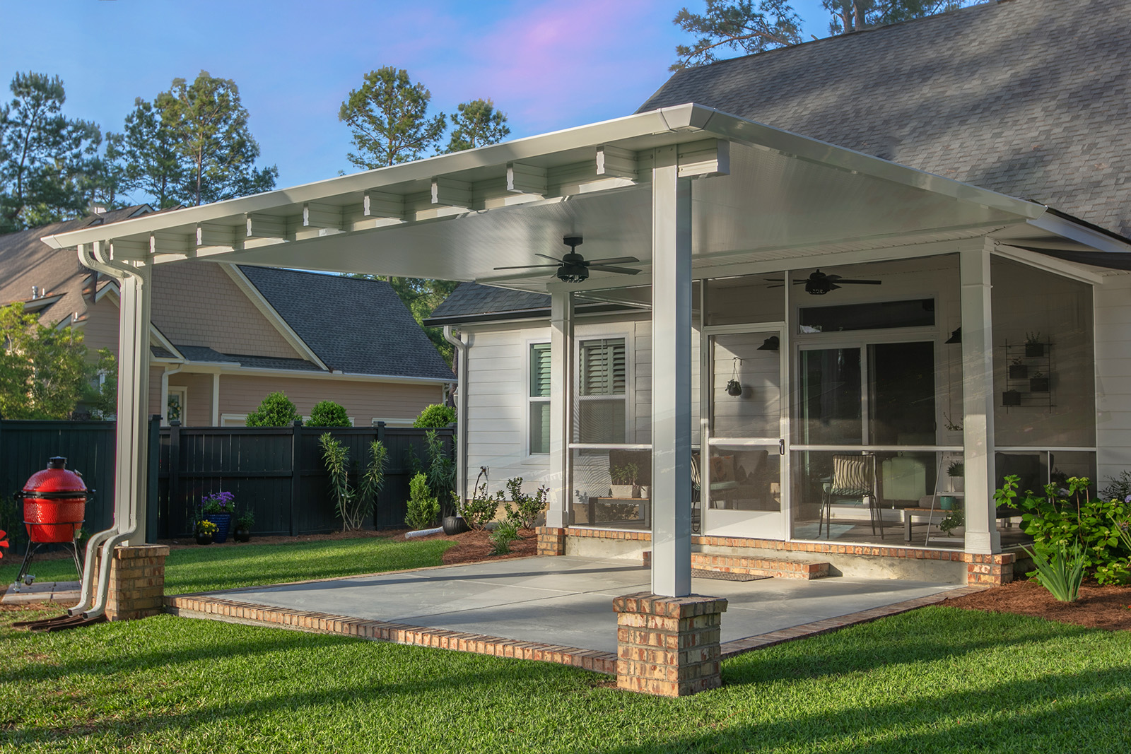 Covered patio with ceiling fans and a spacious backyard area