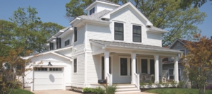 Charming white two-story home with a covered front porch and detached garage